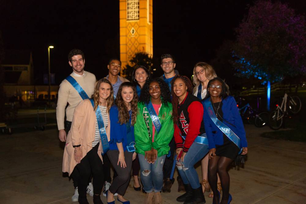 Homecoming court group photo in front of the GVSU clocktower